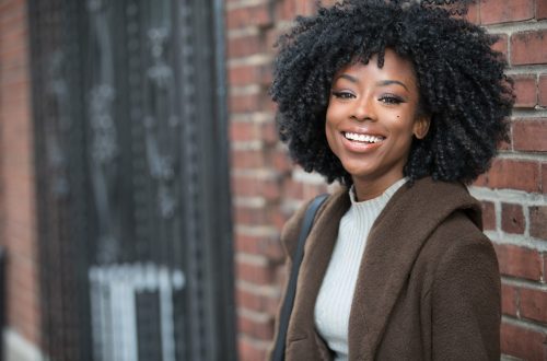 happy-african-american-woman-near-brick-wall-outsi-2022-06-14-02-05-10-utc